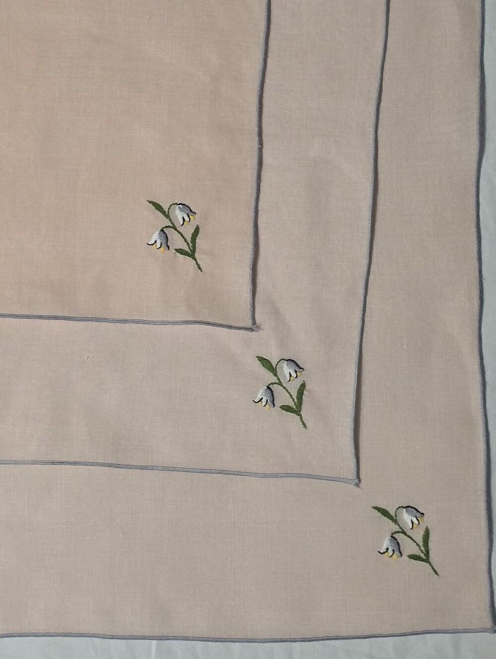 THREE LARGE PINK LINEN NAPKINS WITH EMBRIODERED LILLY OF THE VALLEY ACCENT